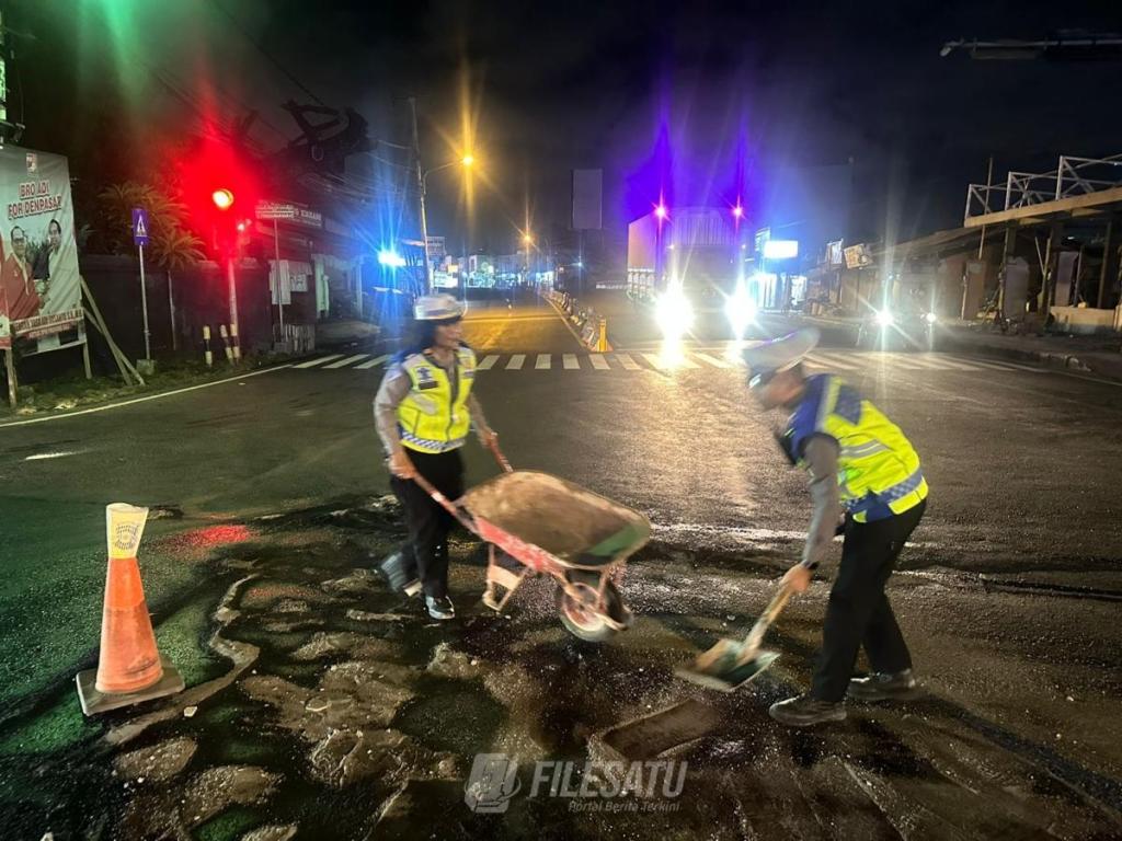 Bahayakan Pengendara, BLP Polsek Denpasar Barat Bersihkan Tumpahan Oli Disimpang Buagan